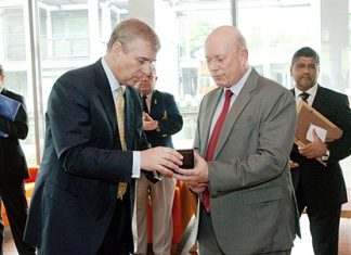 Graham MacDonald, president of the Royal British Legion Thailand presents Prince Andrew with a Legion Coin.